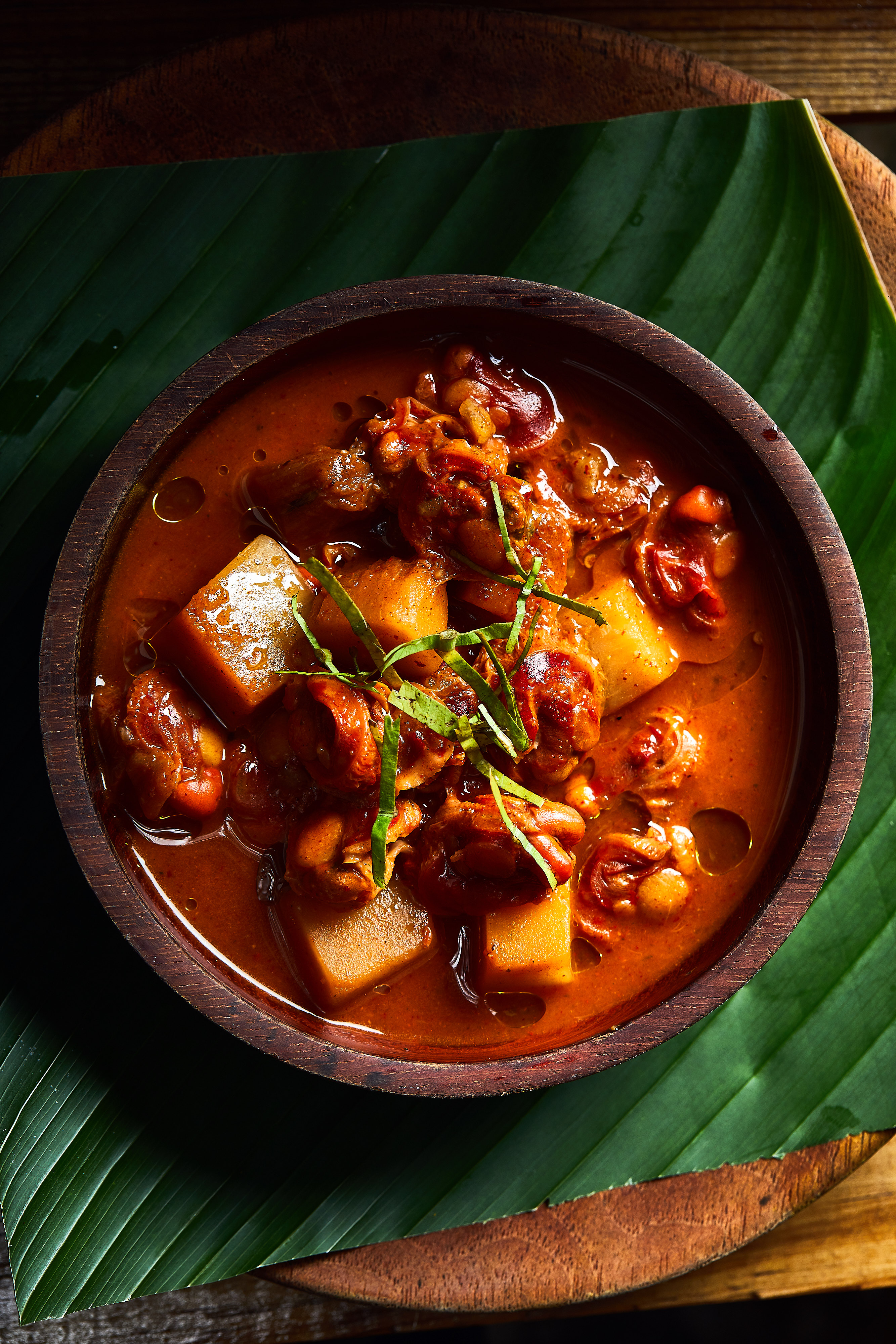 Guiso de mariscos isleño en recipiente de madera sobre hoja de plátano