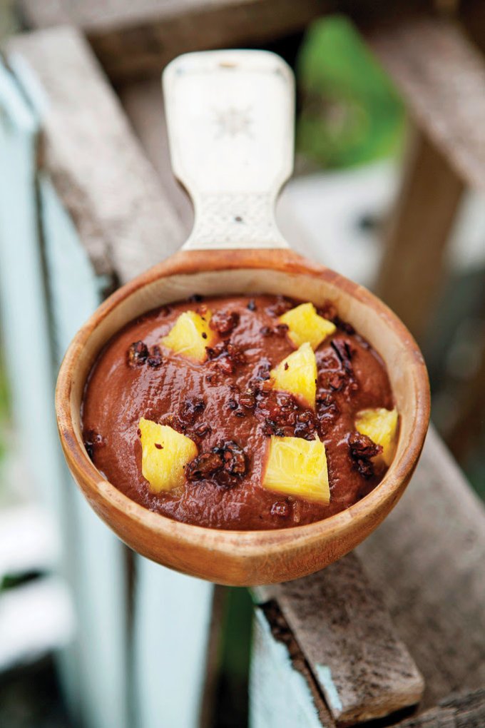 Postre tropical de chocolate con piña en cuenco de madera